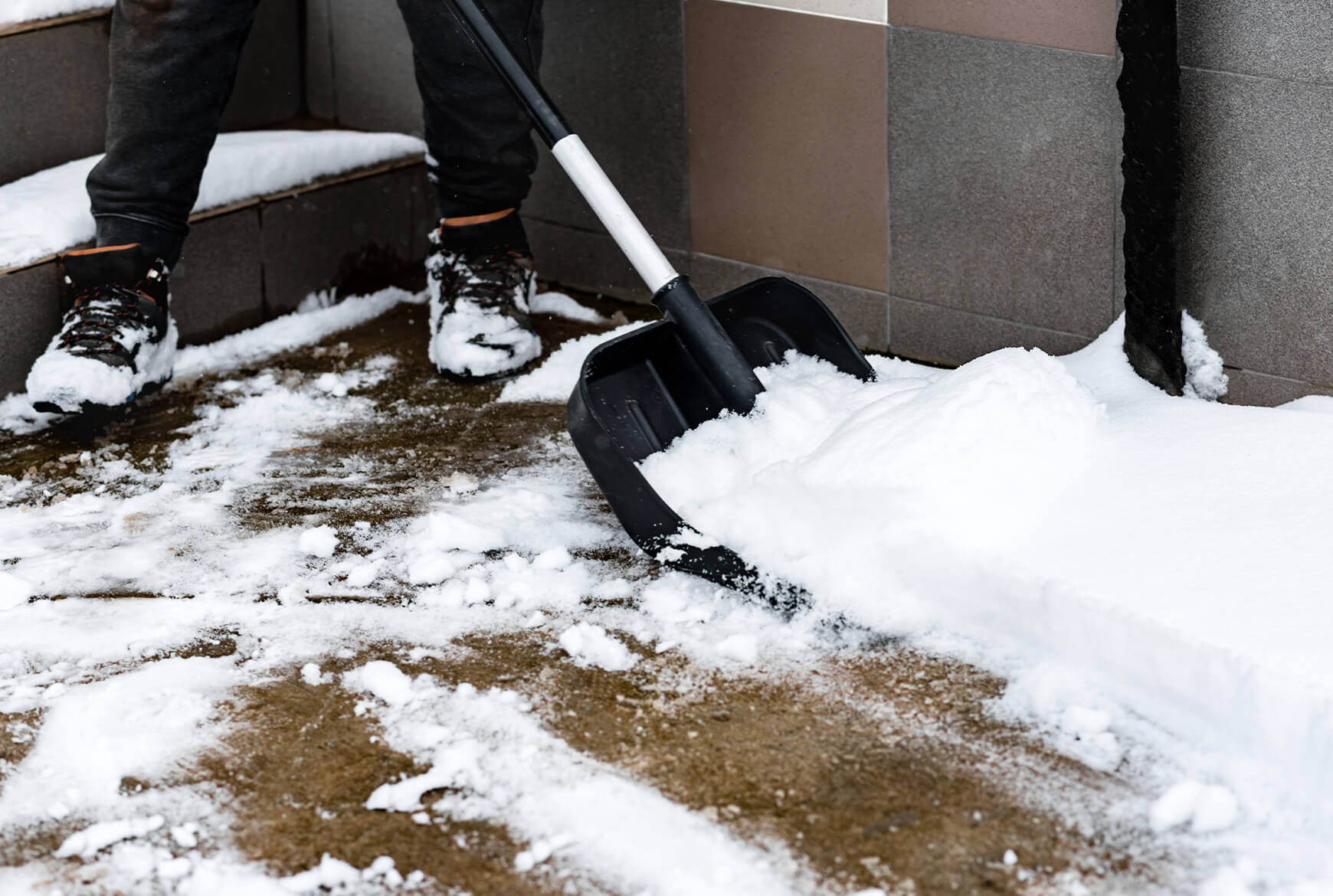 Quelqu'un pellete de la neige dans une entrée