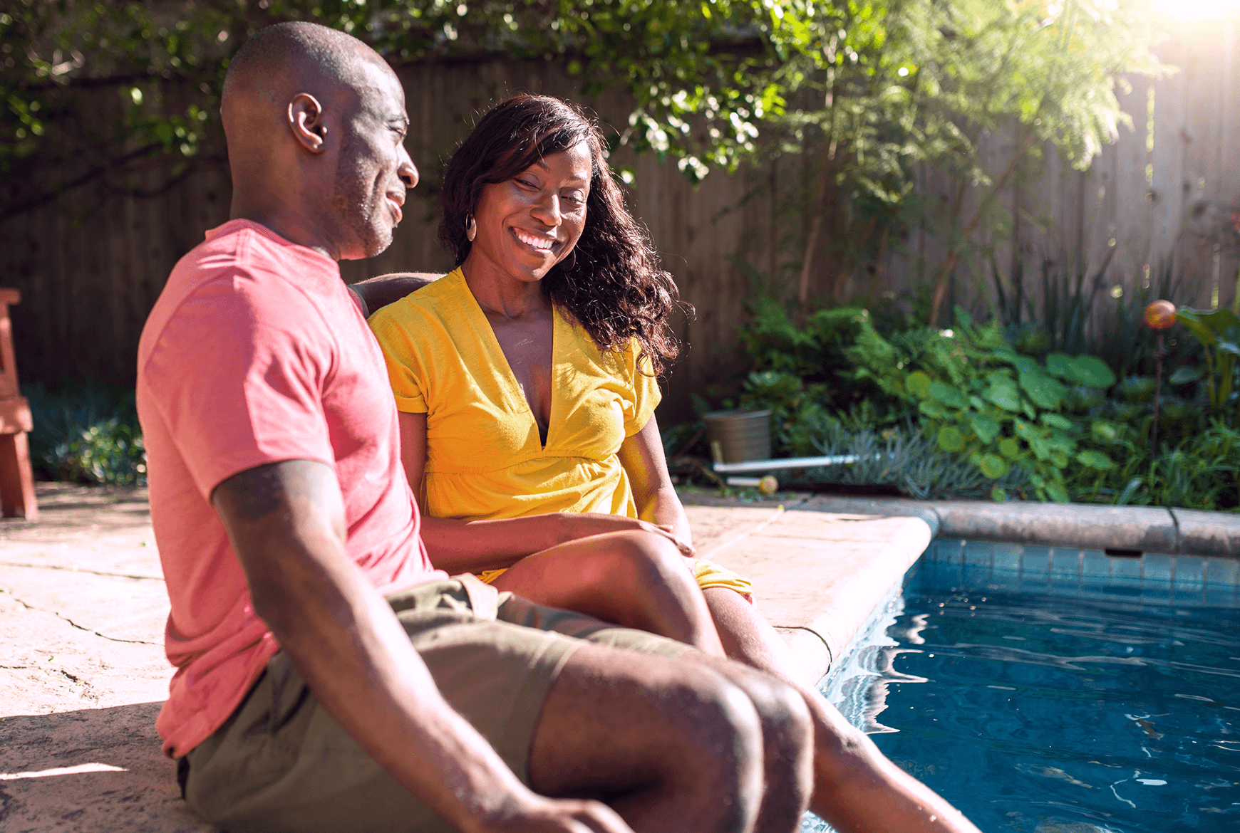 Un couple est assis sur le bord d'une piscine