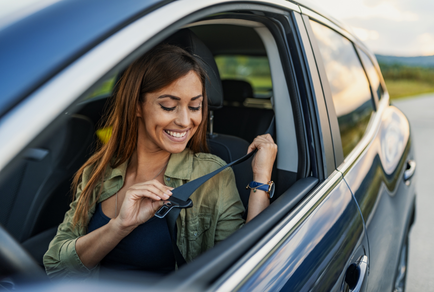 Une femme attache sa ceinture en voiture