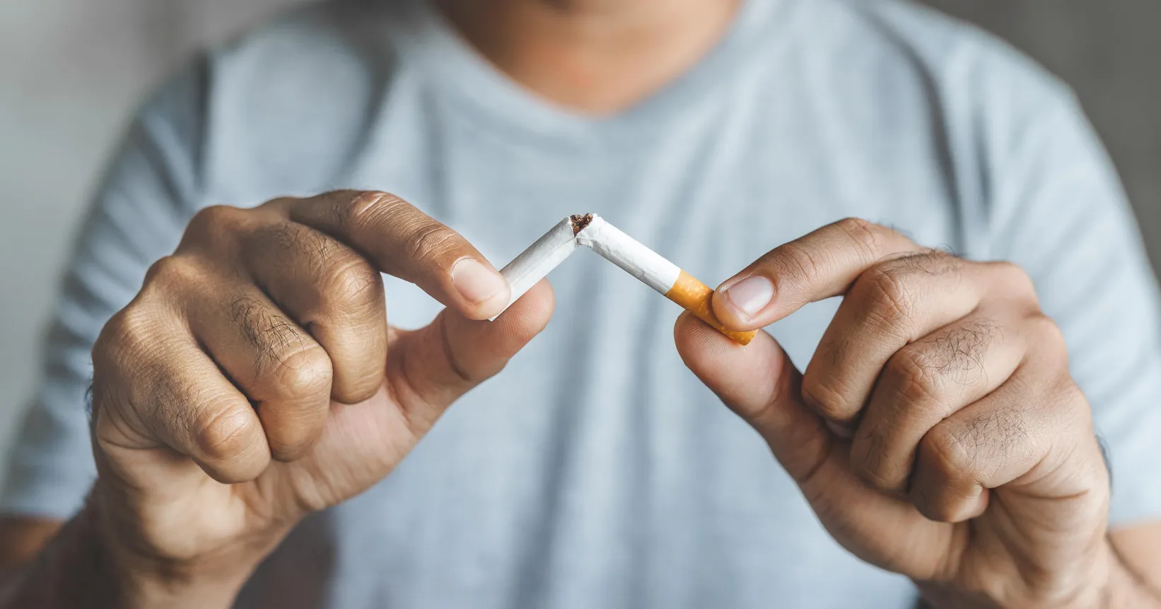 homme qui casse une cigarette