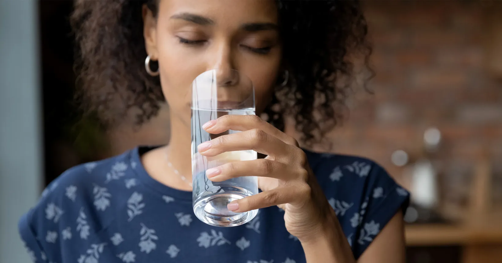 Femme qui boit un verre d'eau.