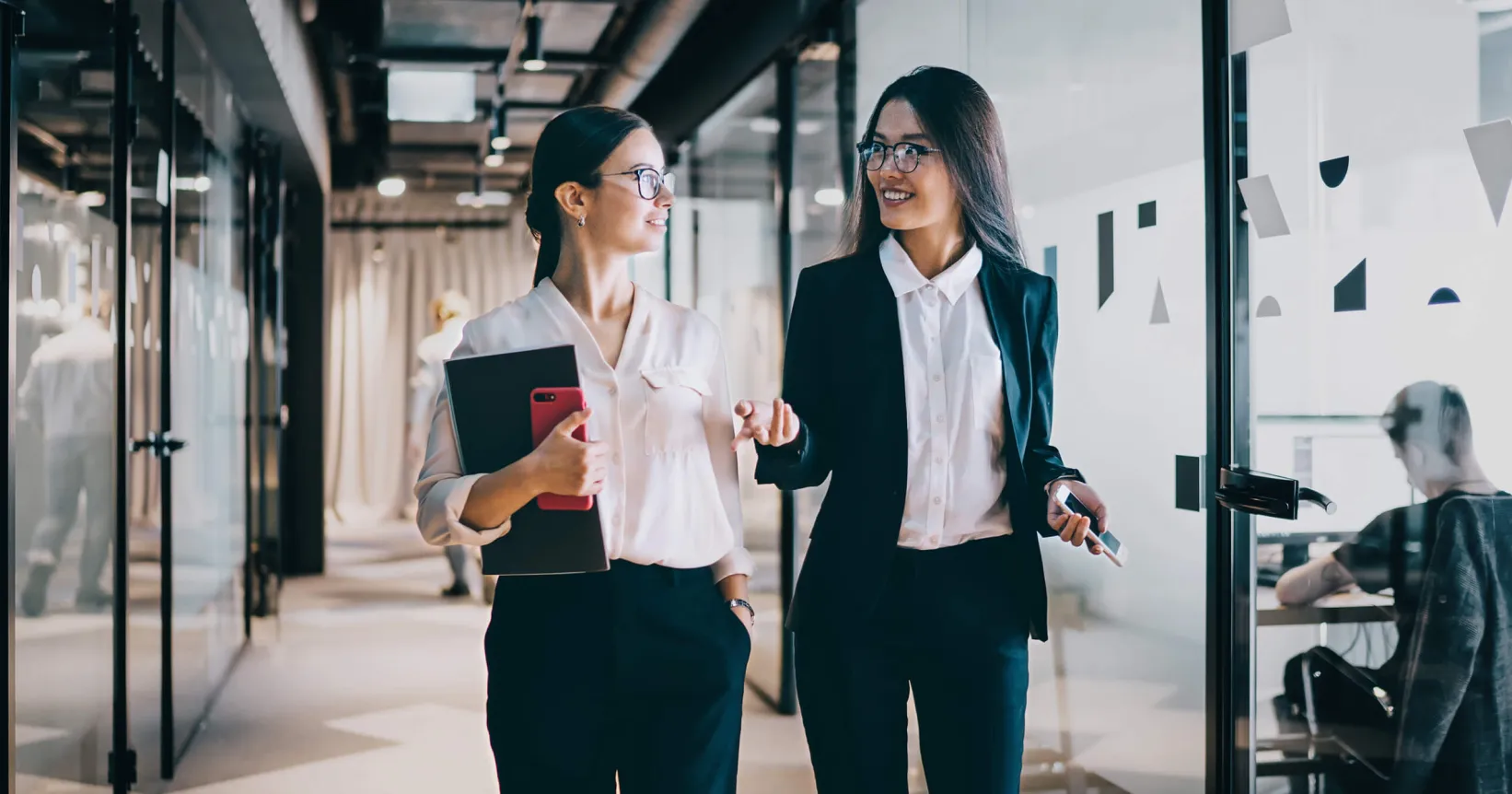 Deux femmes d'affaires discutent dans un corridor
