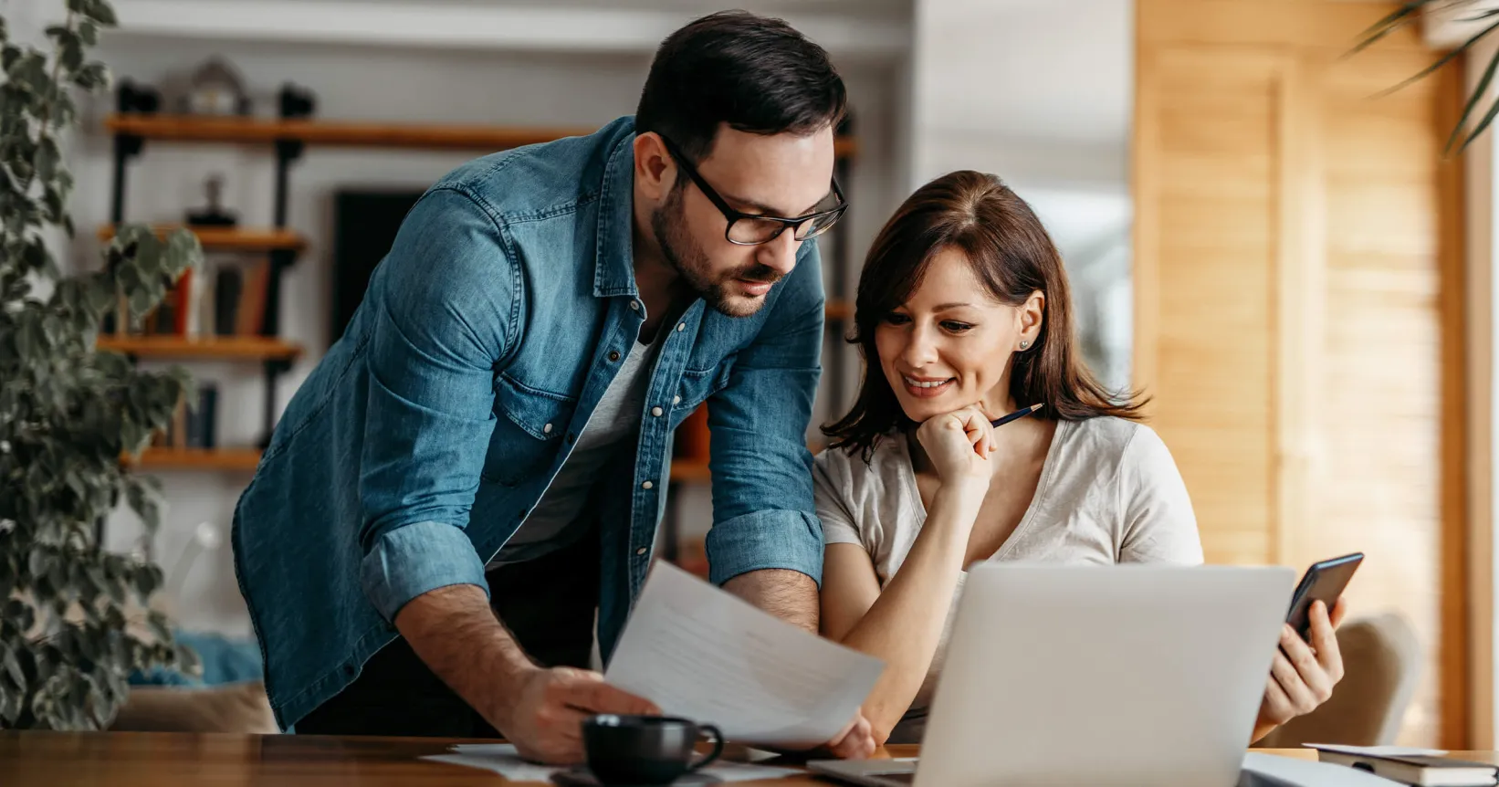 Un homme et une femme consultent des documents devant un ordinateur