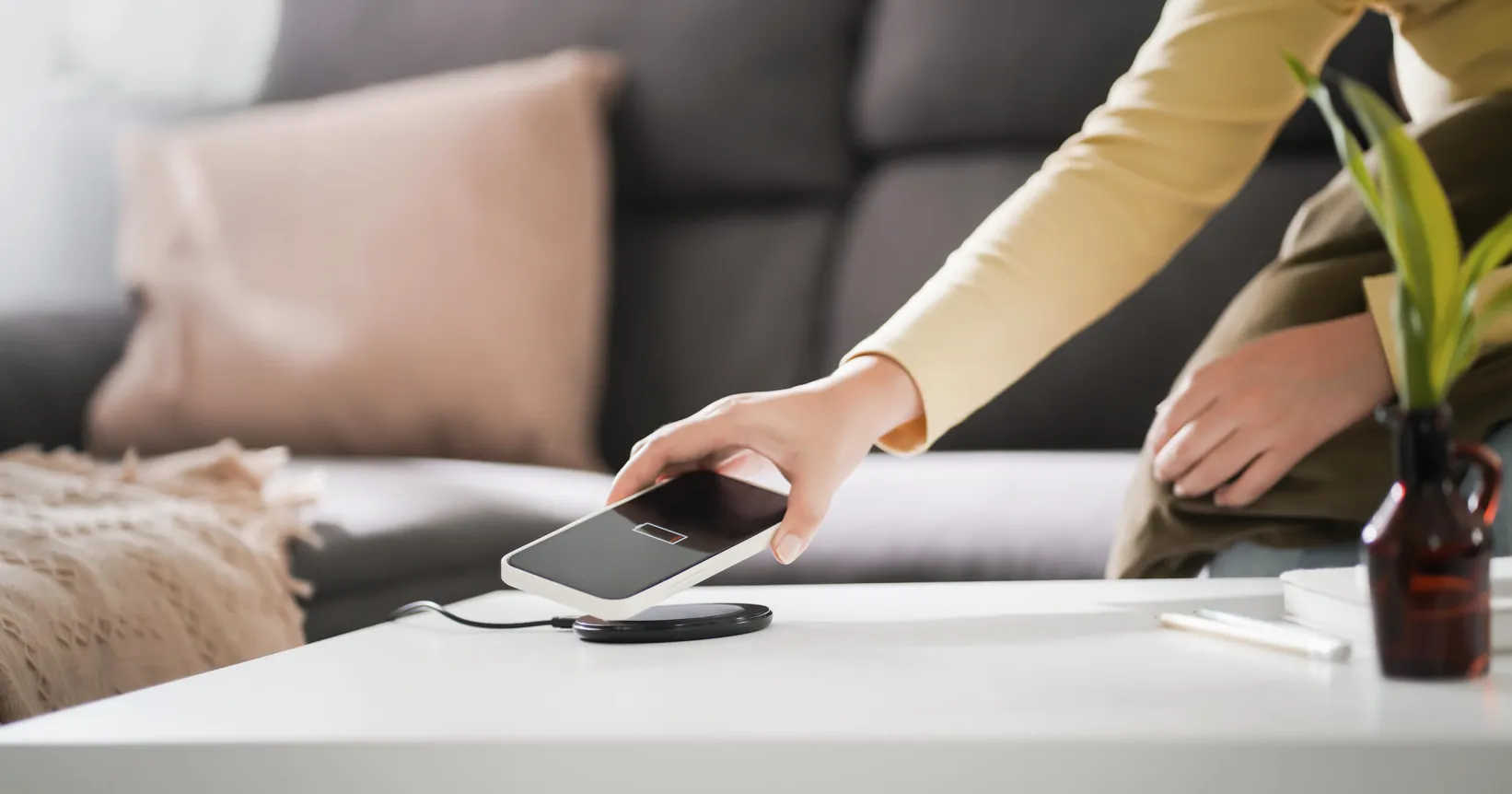 Une personne dépose un téléphone cellulaire sur une table