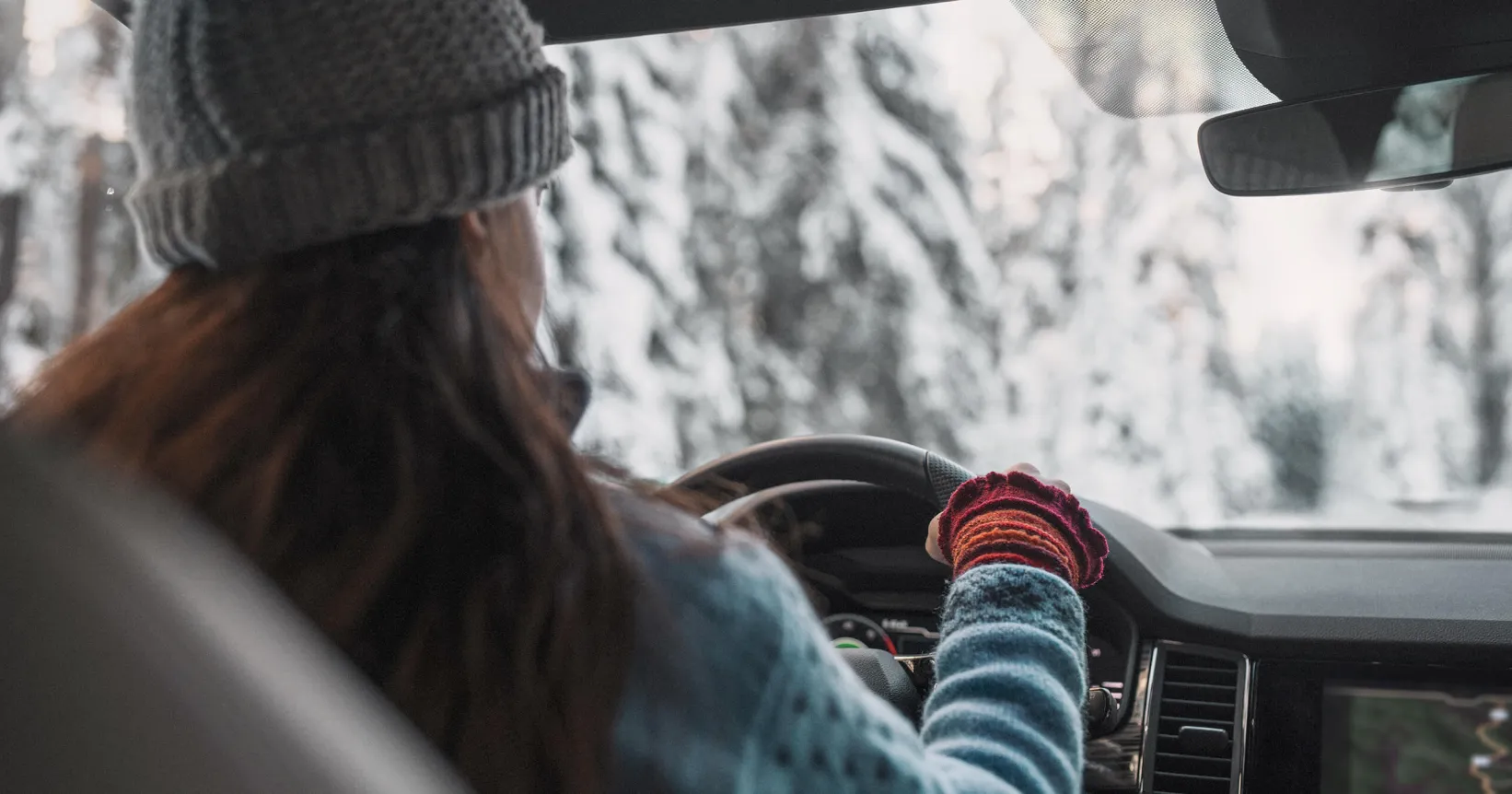 Une femme conduit une voiture en hiver