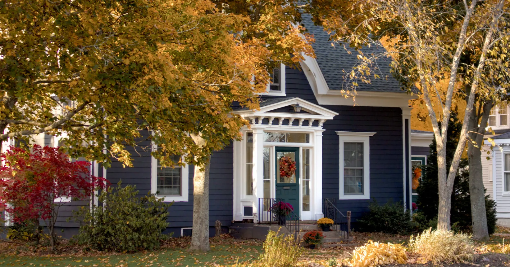 Une maison entourée d'arbres à l'automne