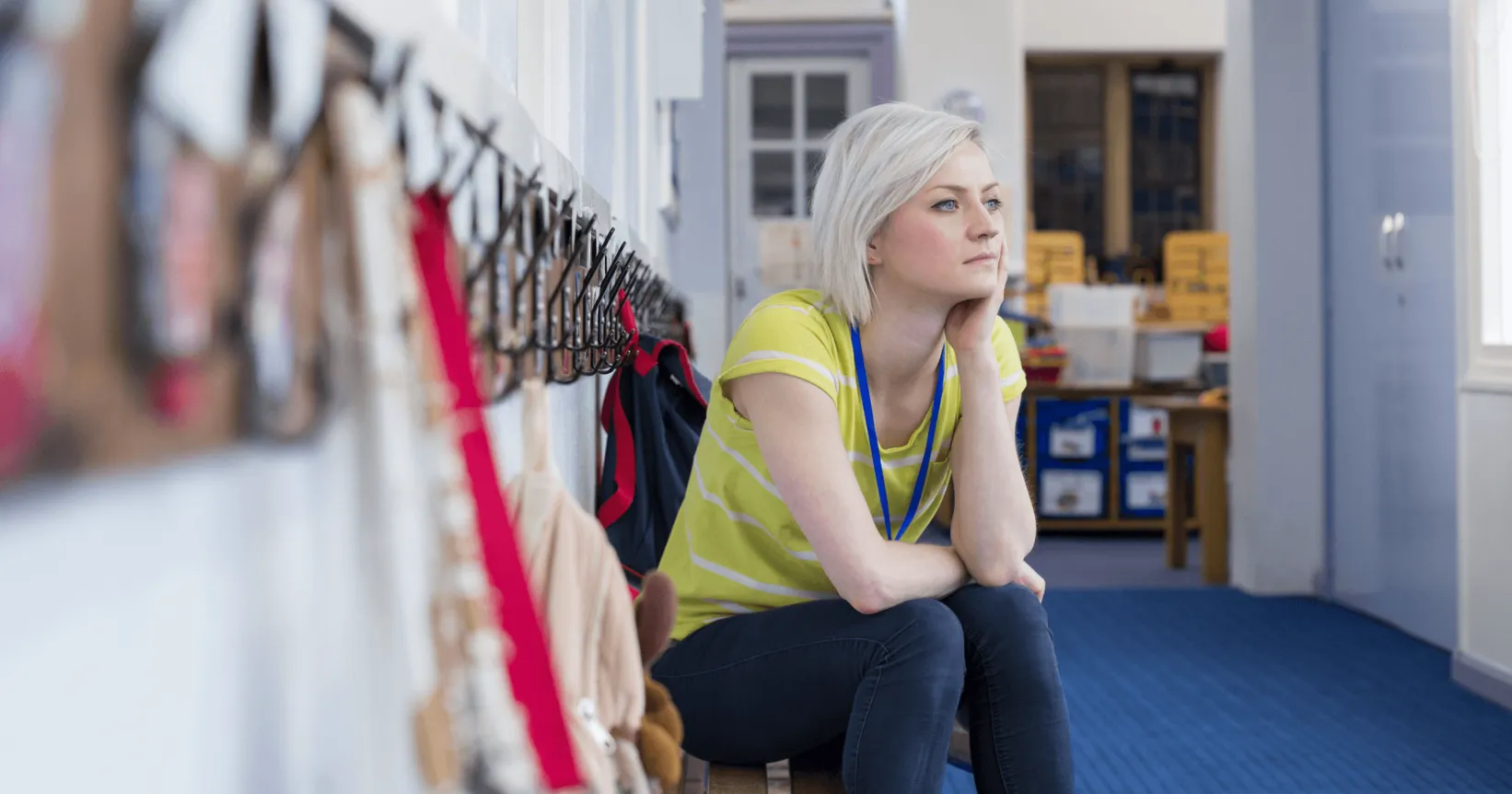 Une femme est assise sur un banc dans un corridor