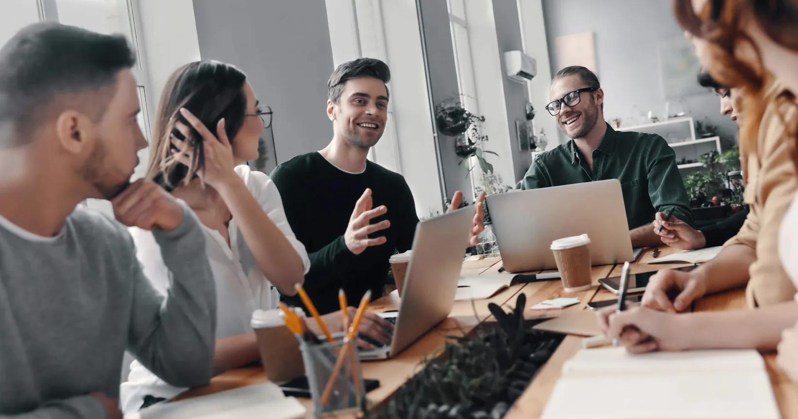 Un groupe d'employés discutent autour d'une table de réunion