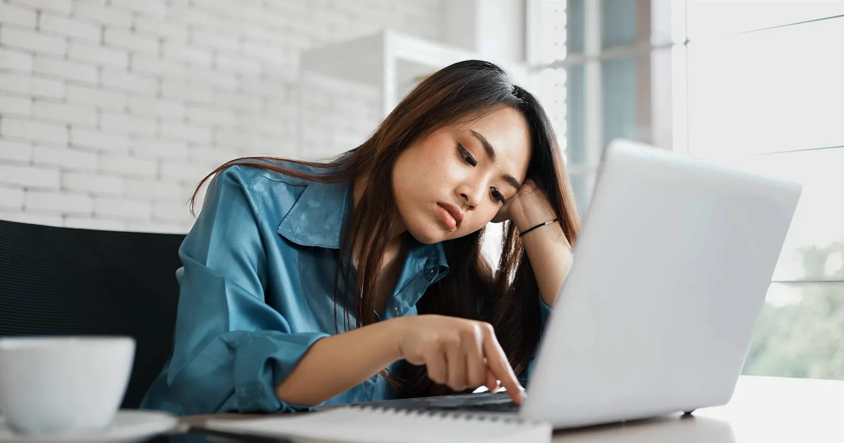 Une femme s'ennuie devant son ordinateur portable