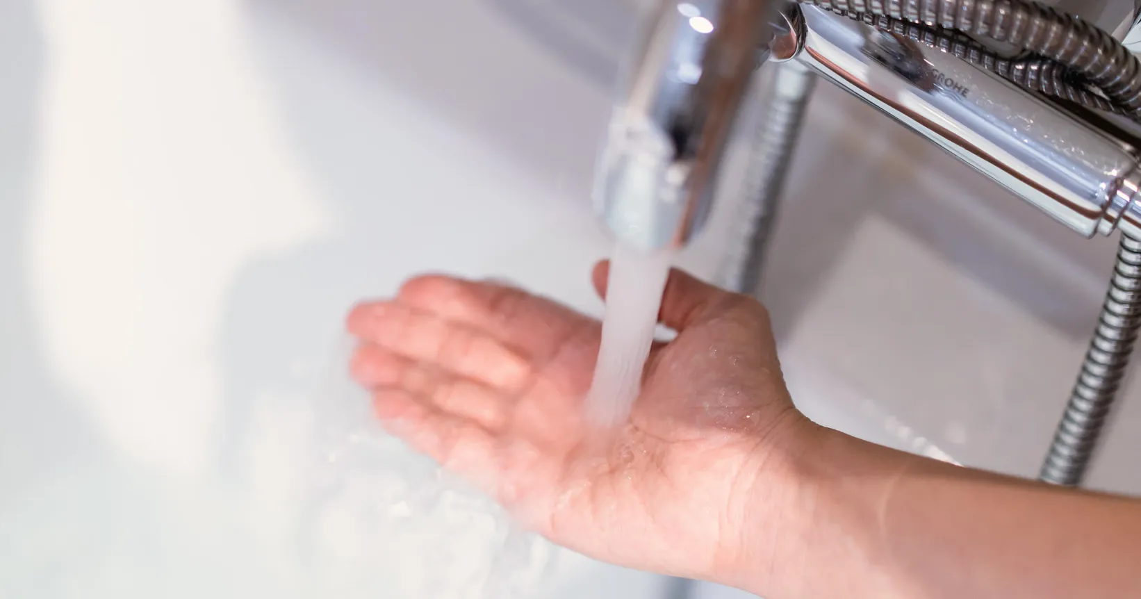 Quelqu'un passe sa main sous l'eau du robinet