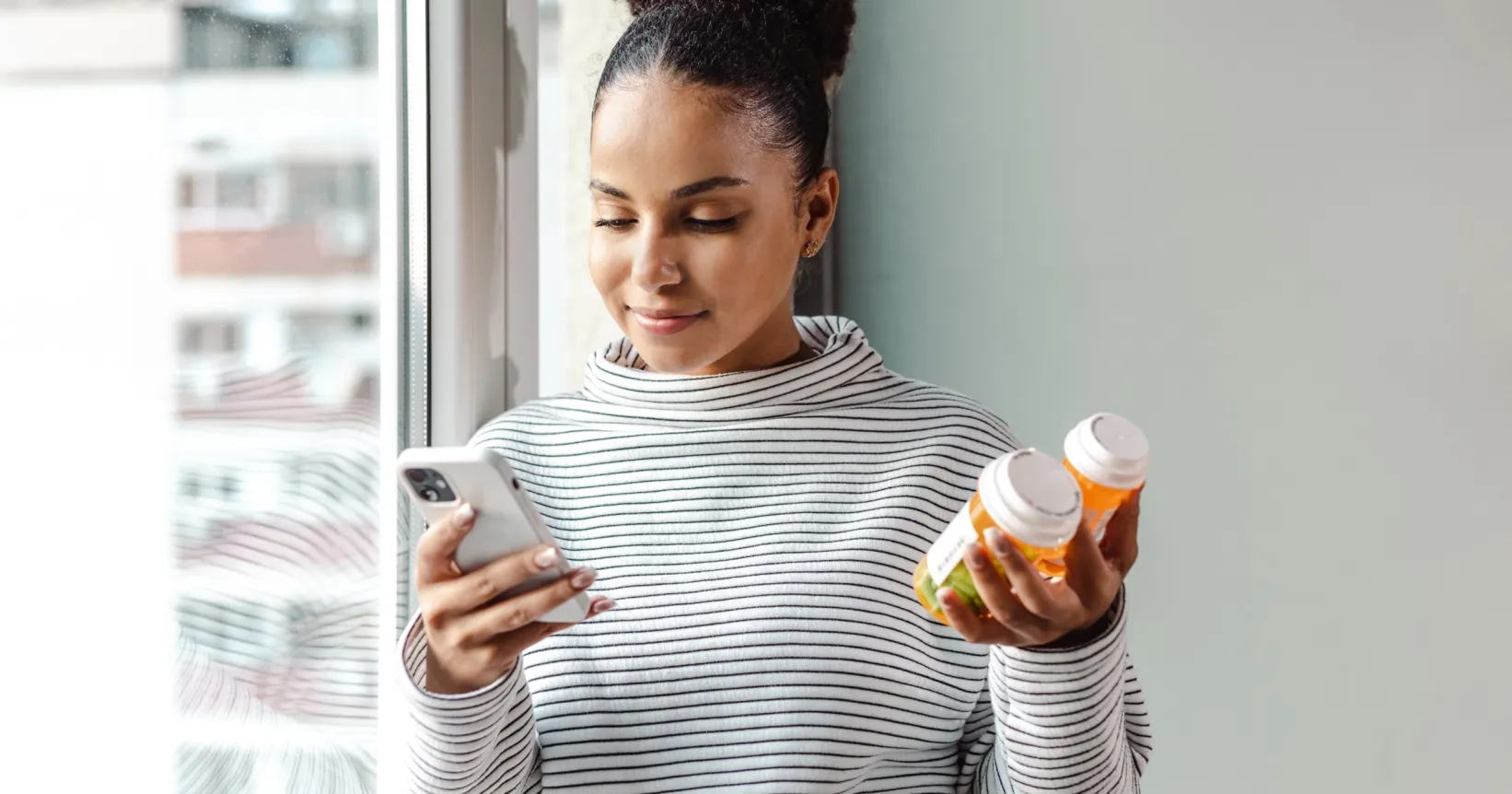 Une femme tient des bouteilles de médicaments dans sa main