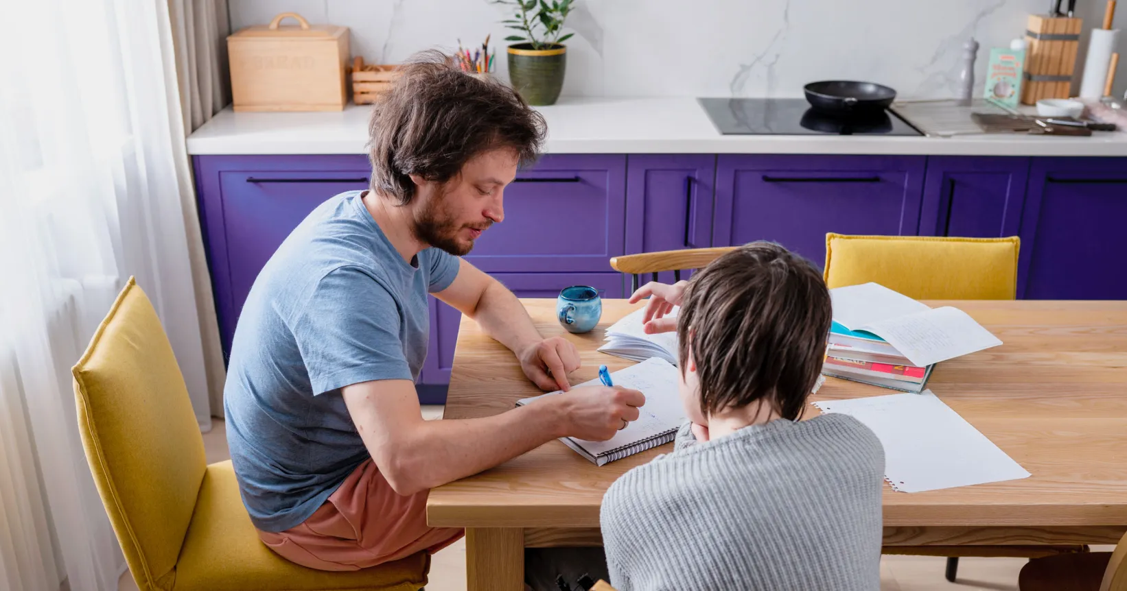 Un père aide son enfant à faire ses devoirs