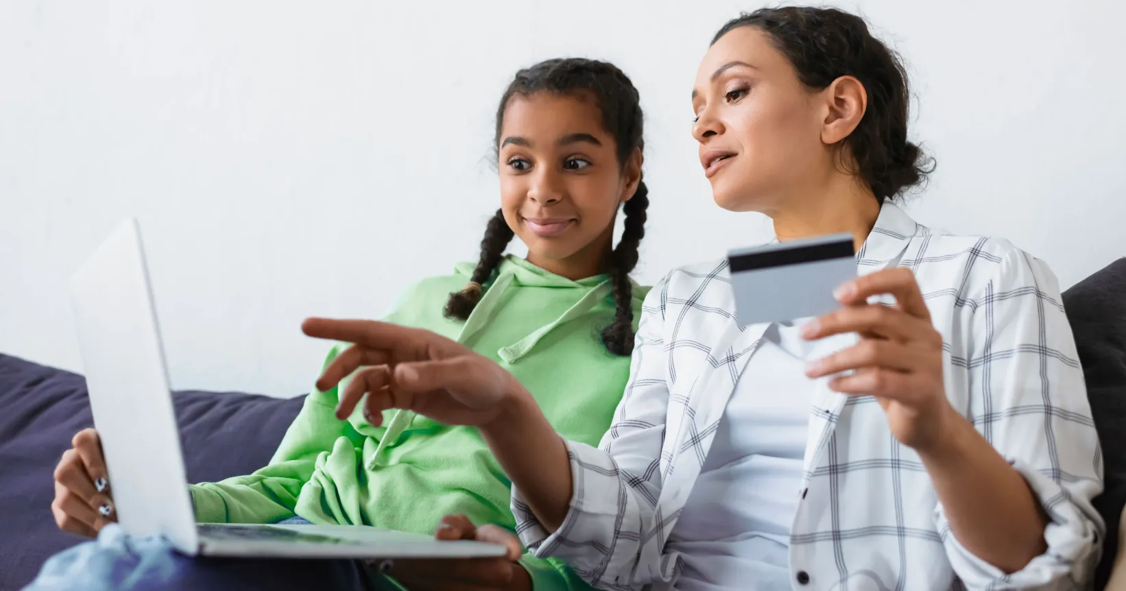 Une mère et sa fille consultent un ordinateur