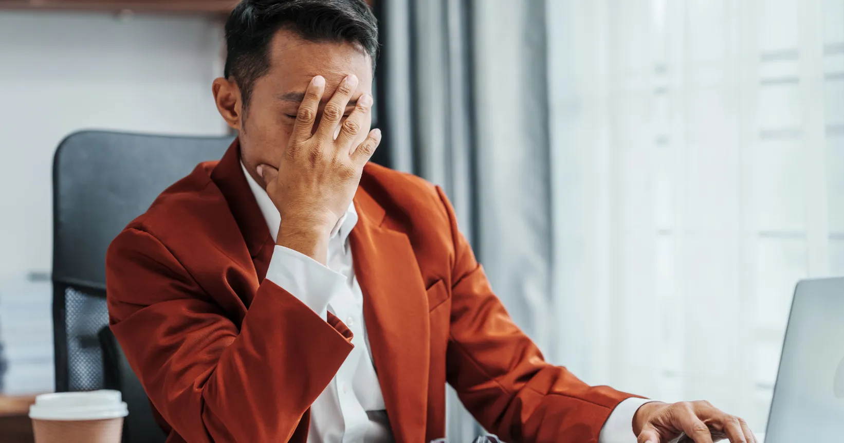 Un homme tient son visage dans ses mains