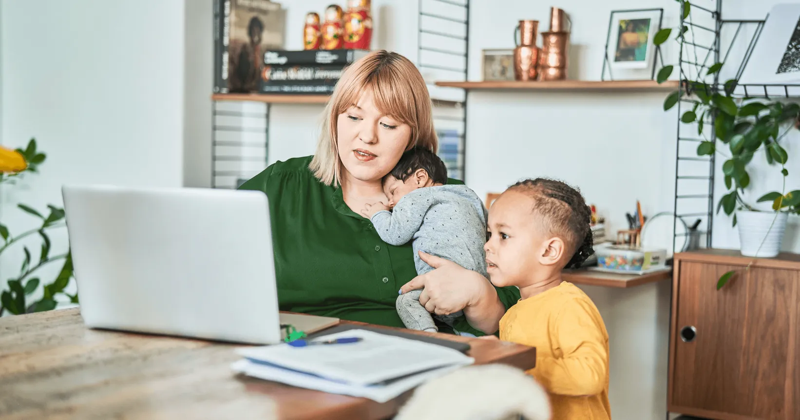 Une mère et ses enfants consultent un ordinateur portable