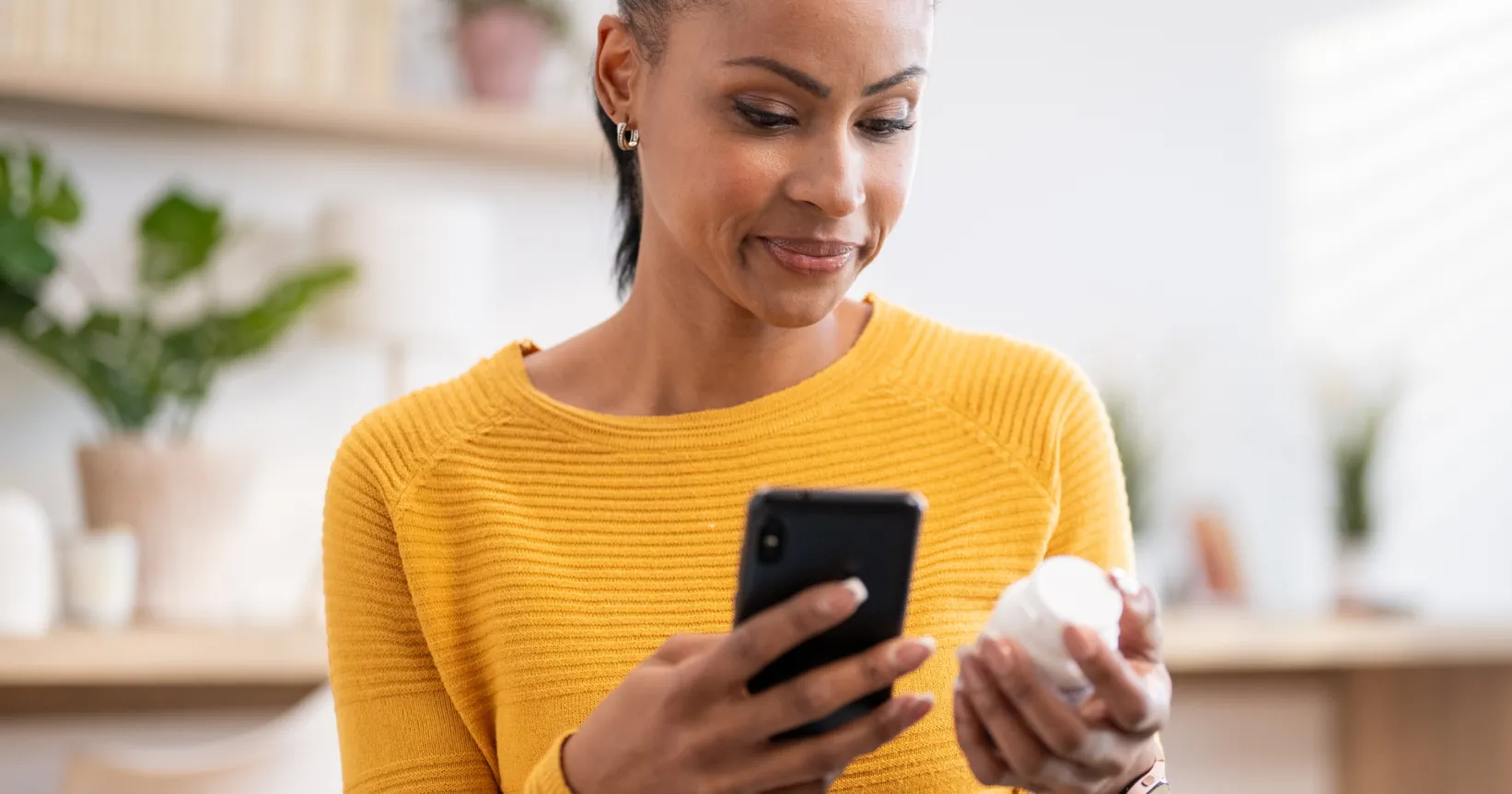 Une femme tient un pot de médicaments