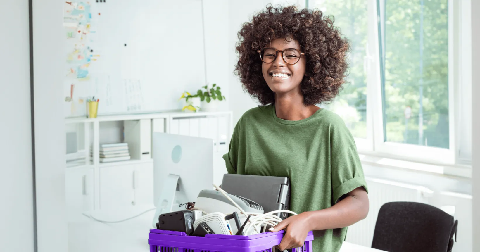 Une femme tient un bac rempli d'électroniques