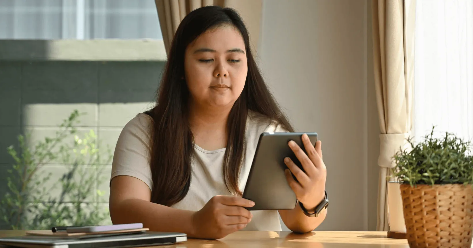 Un femme lit sur une tablette électronique