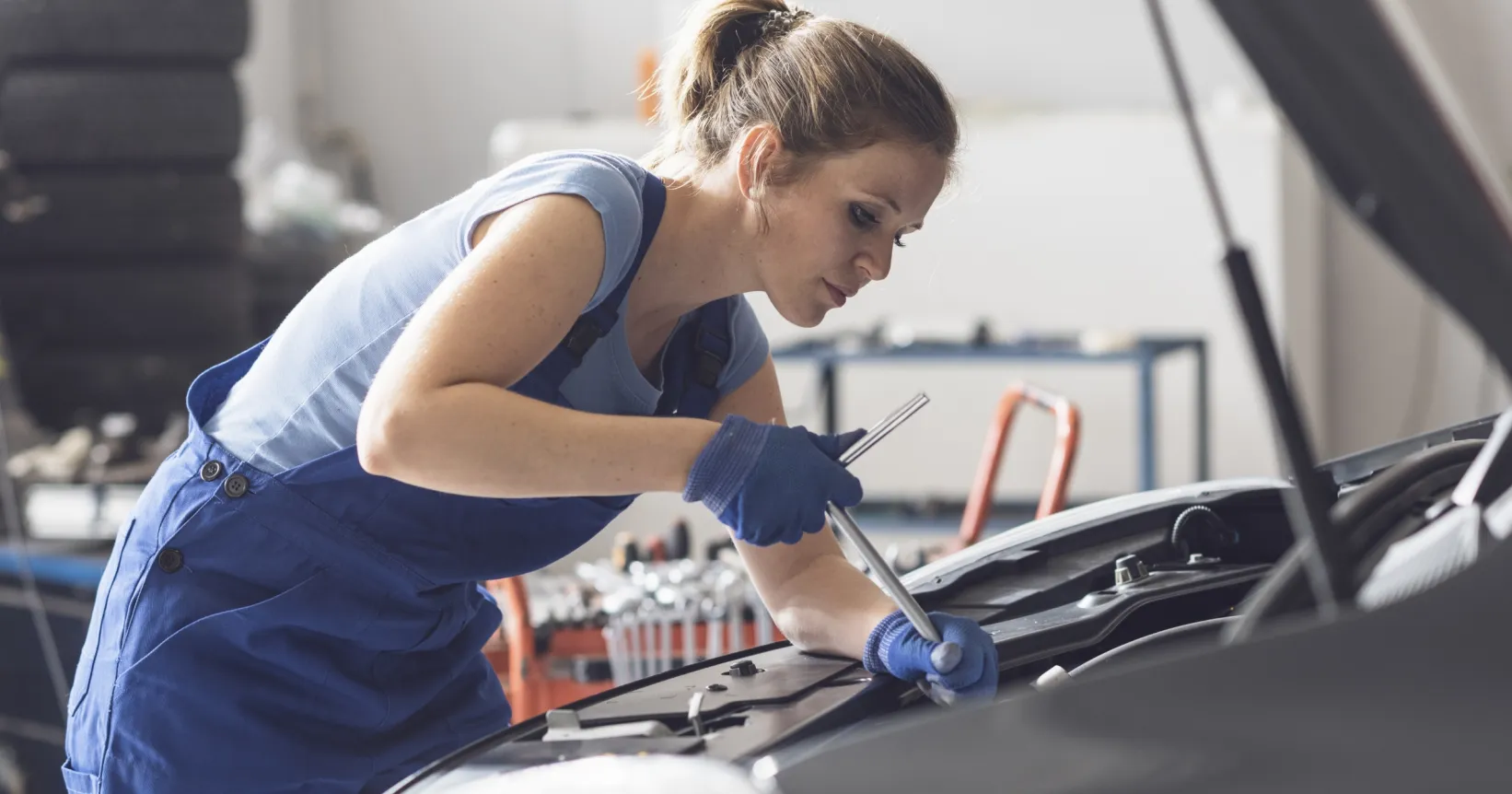 Une garagiste travaille sur une voiture