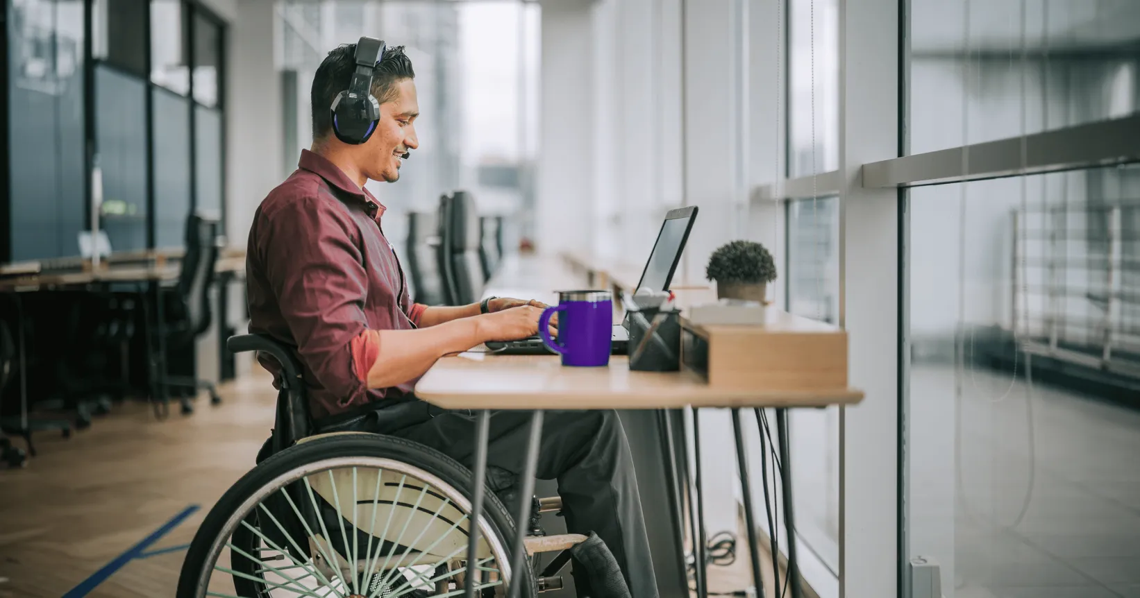 Une personne en chaise roulante travaille à un bureau
