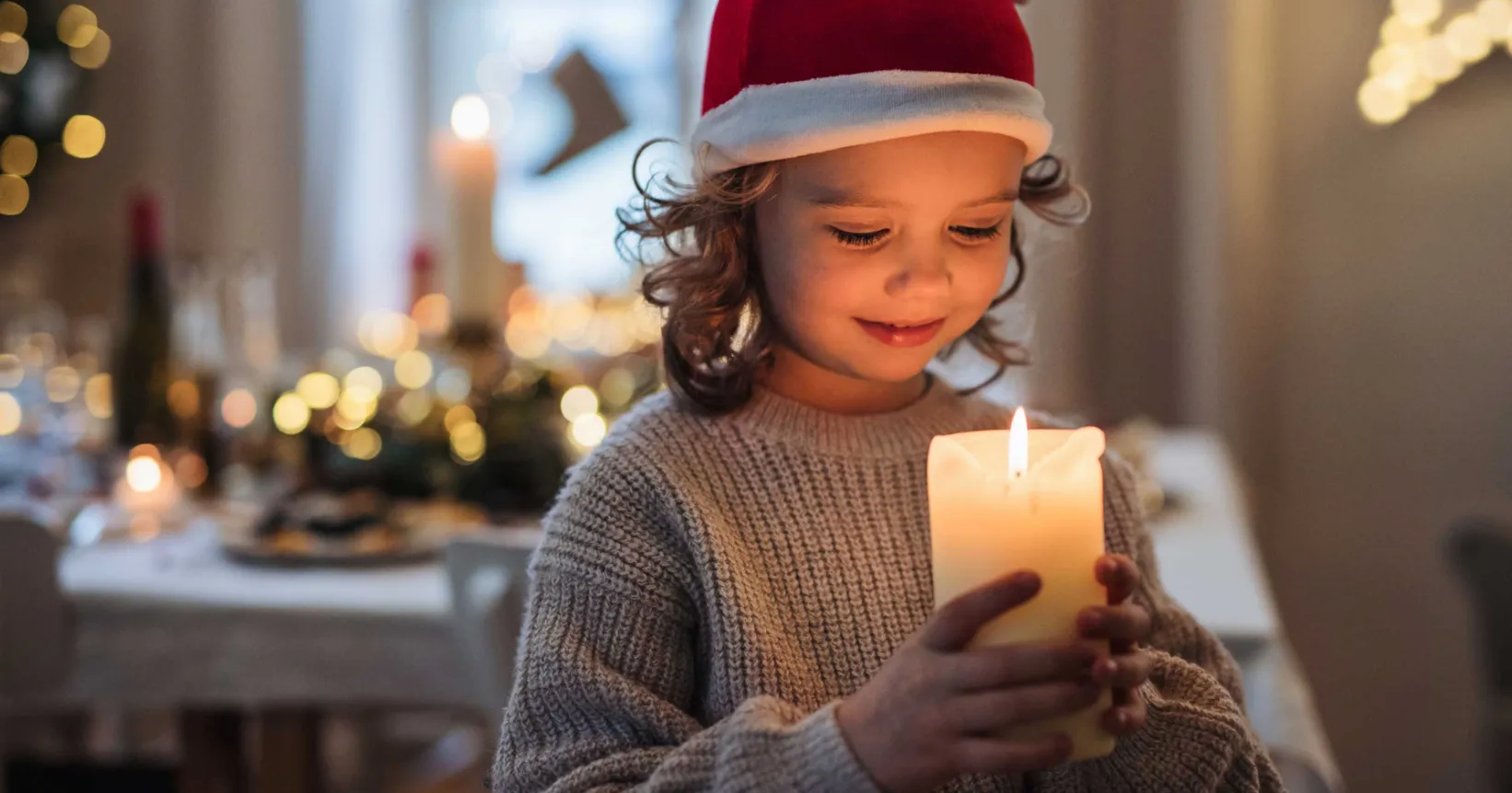 Un enfant tient une bougie allumée