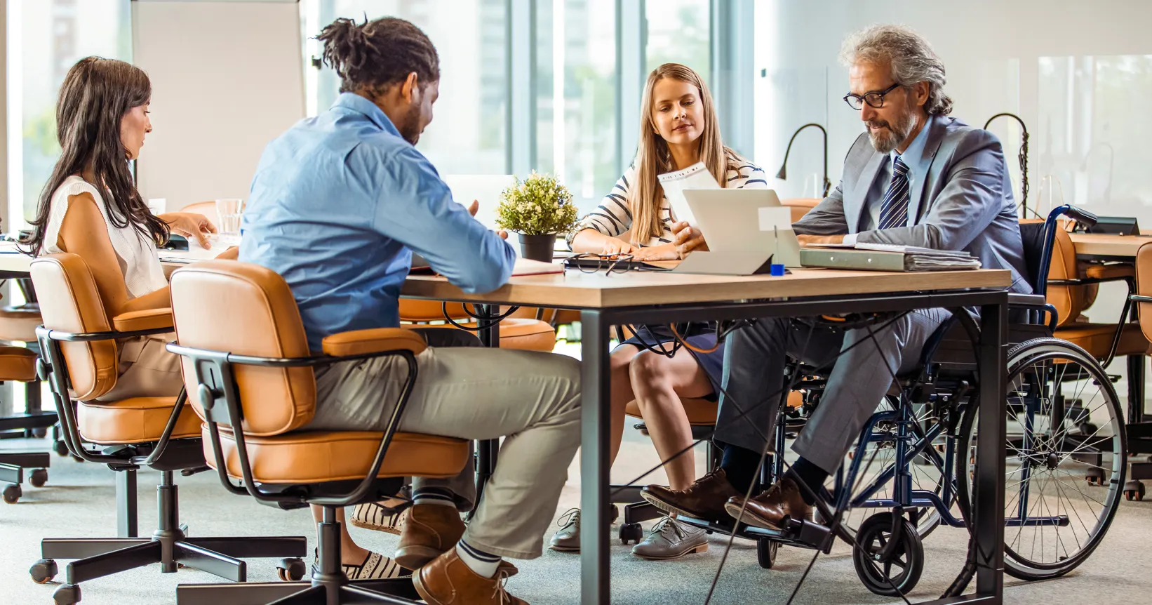 Quatre personnes assises autour d'une table de réunion