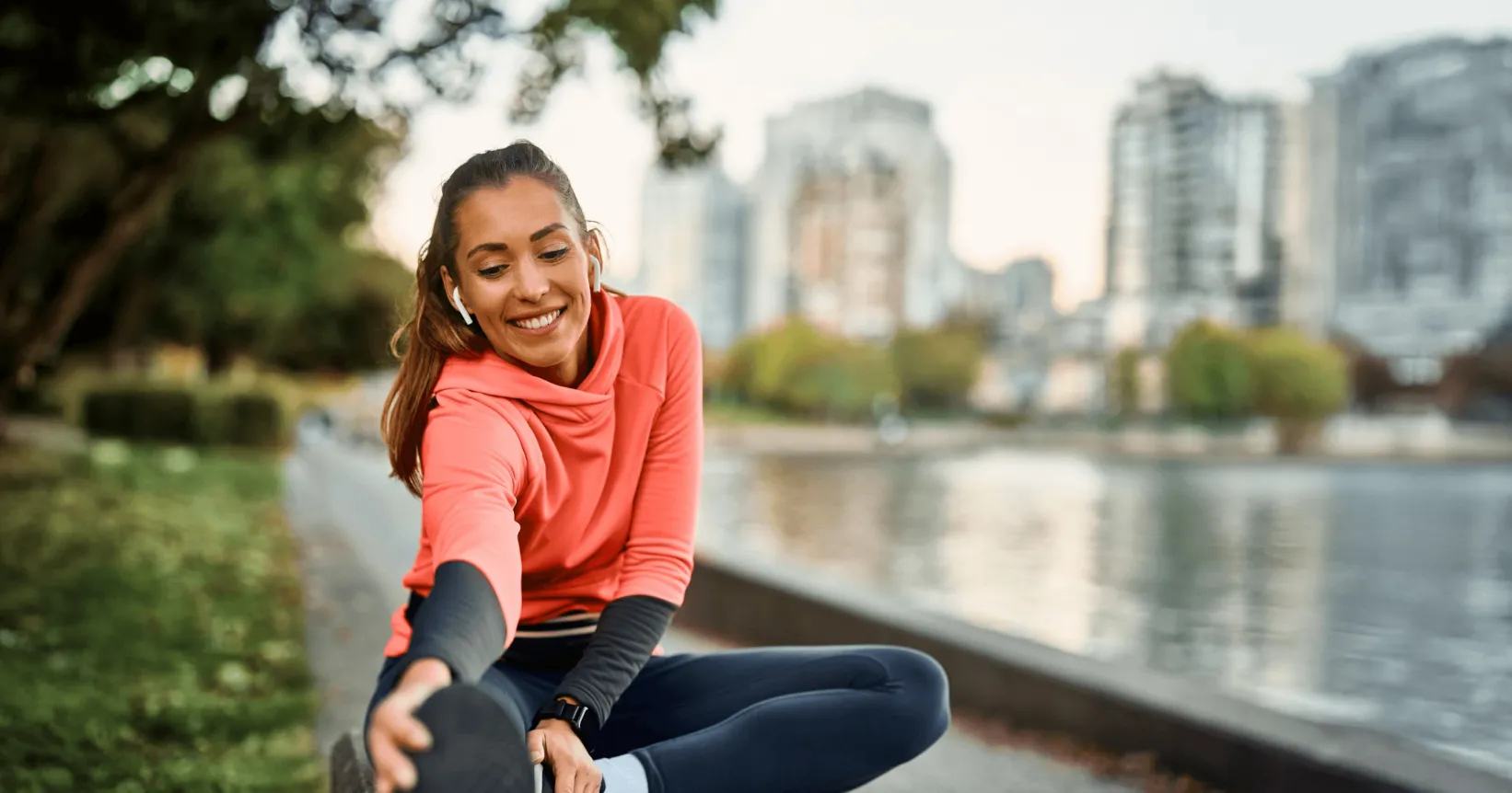 Une femme ayant des écouteurs fait des étirements