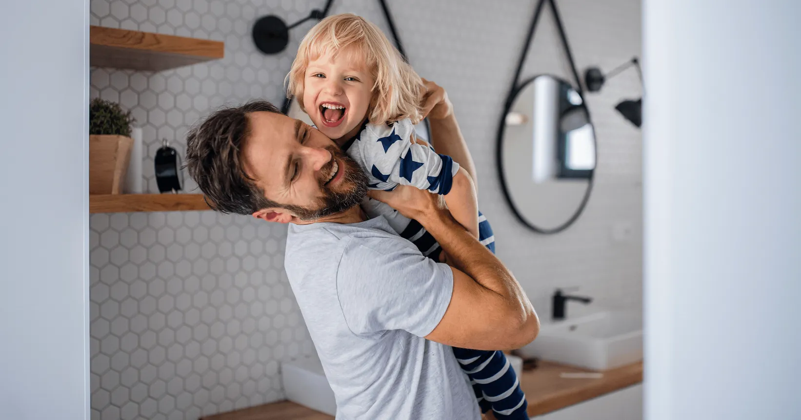 Un homme et un enfant rient dans les bras l'un de l'autre