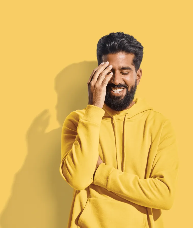 Personne souriante, une main sur le visage