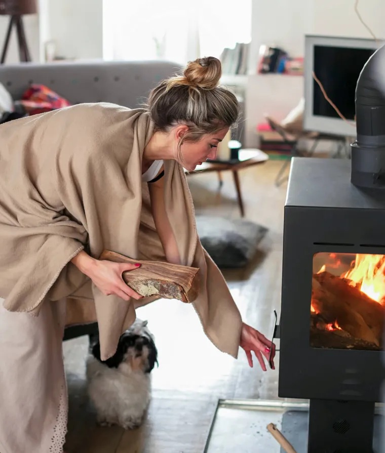 Femme qui alimente un feu de foyer