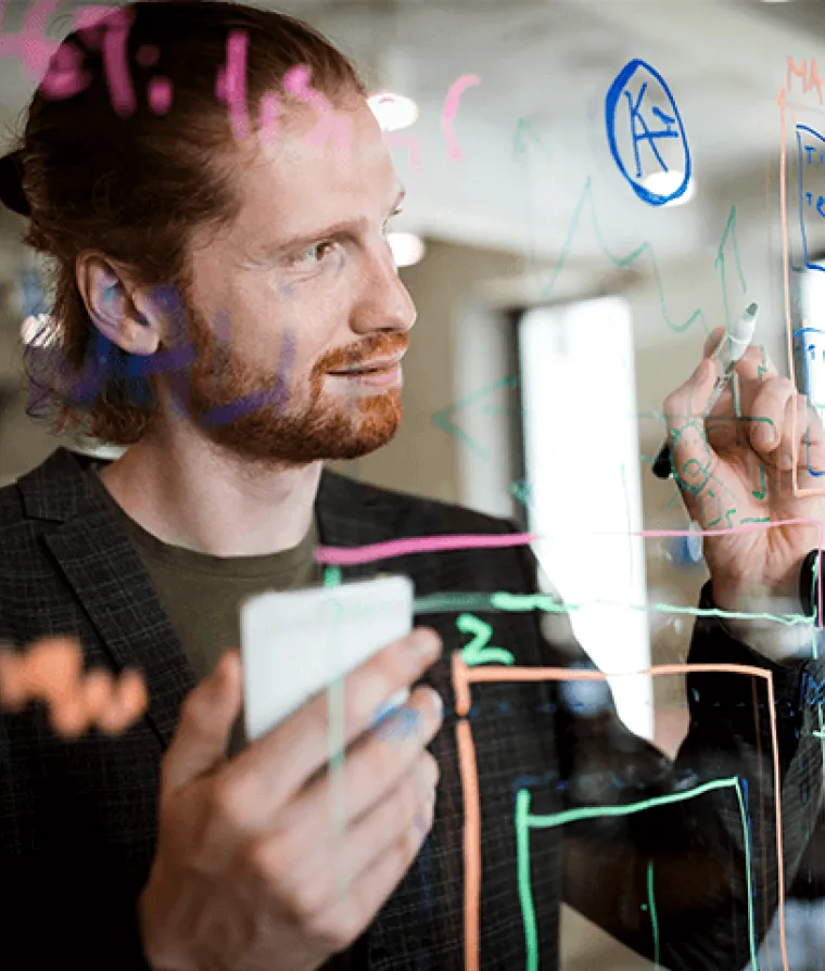 Homme qui écrit sur un tableau effaçable