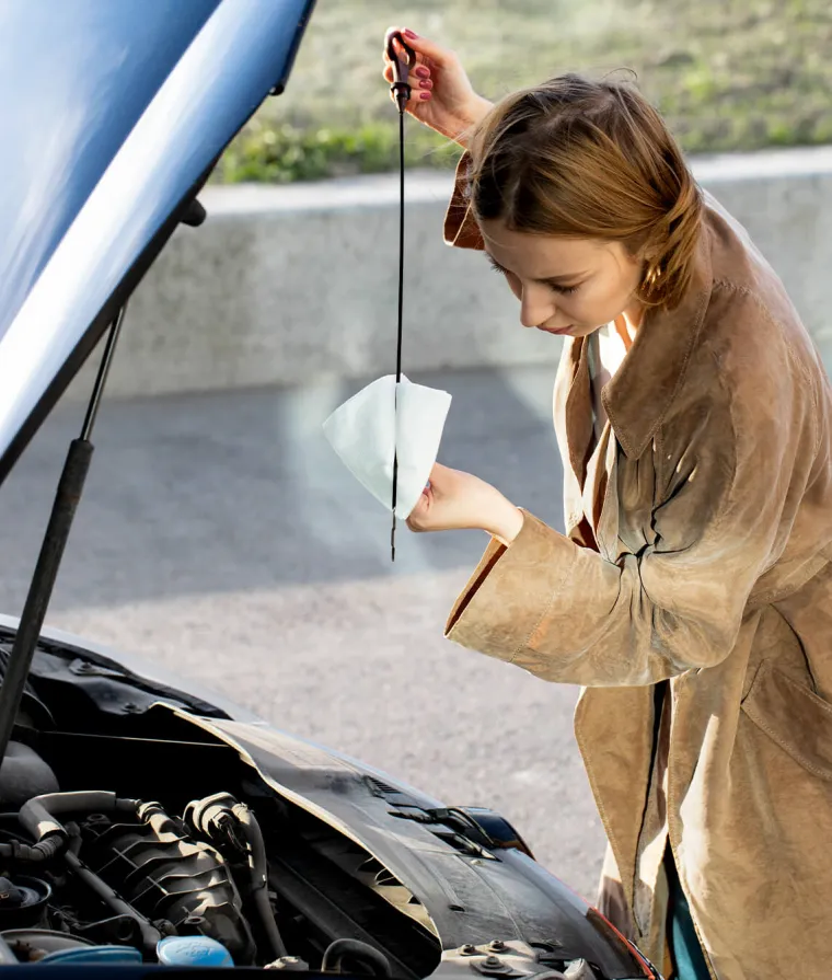 Une femme vérifiant le niveau d'huile