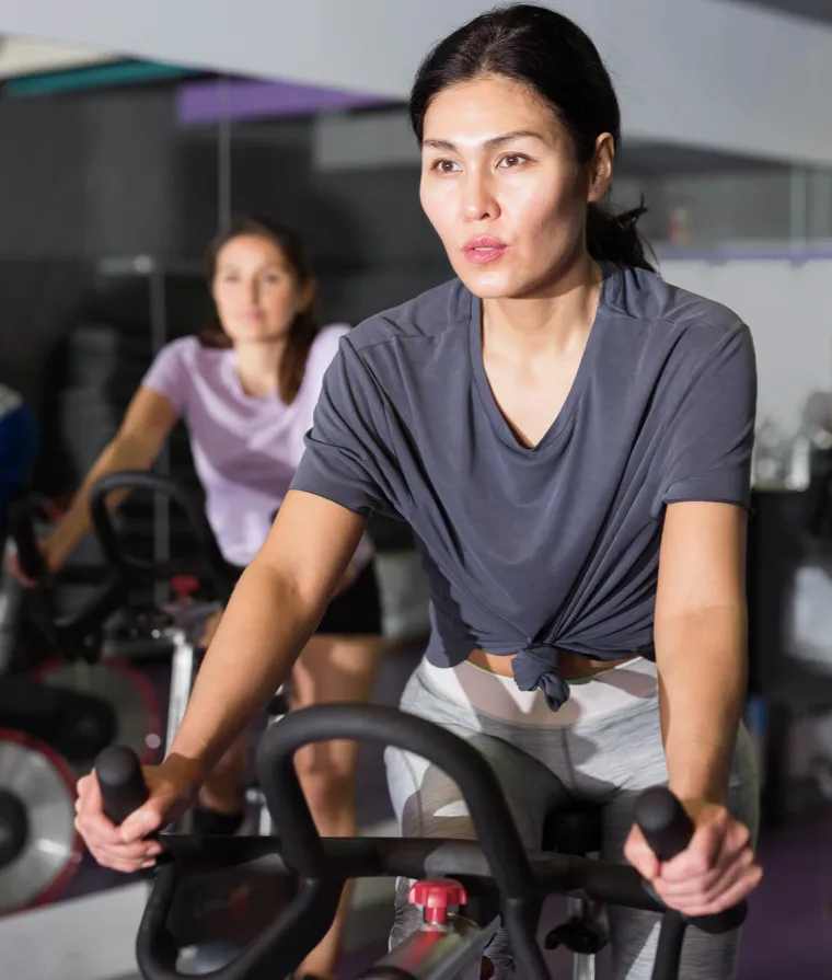 Une femme fait du vélo stationnaire