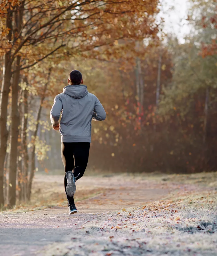Une personne court dans un sentier boisé