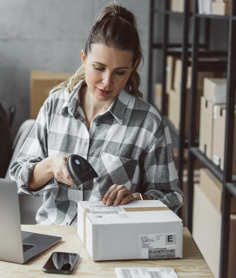Une employée scanne une étiquette sur un colis