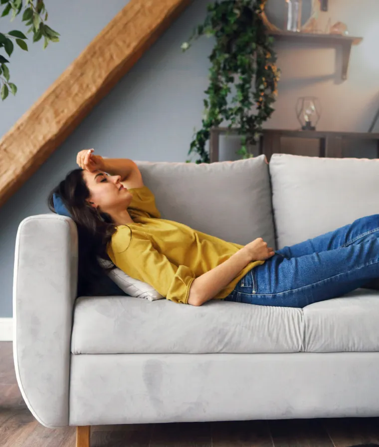 Une femme est allongée sur un divan