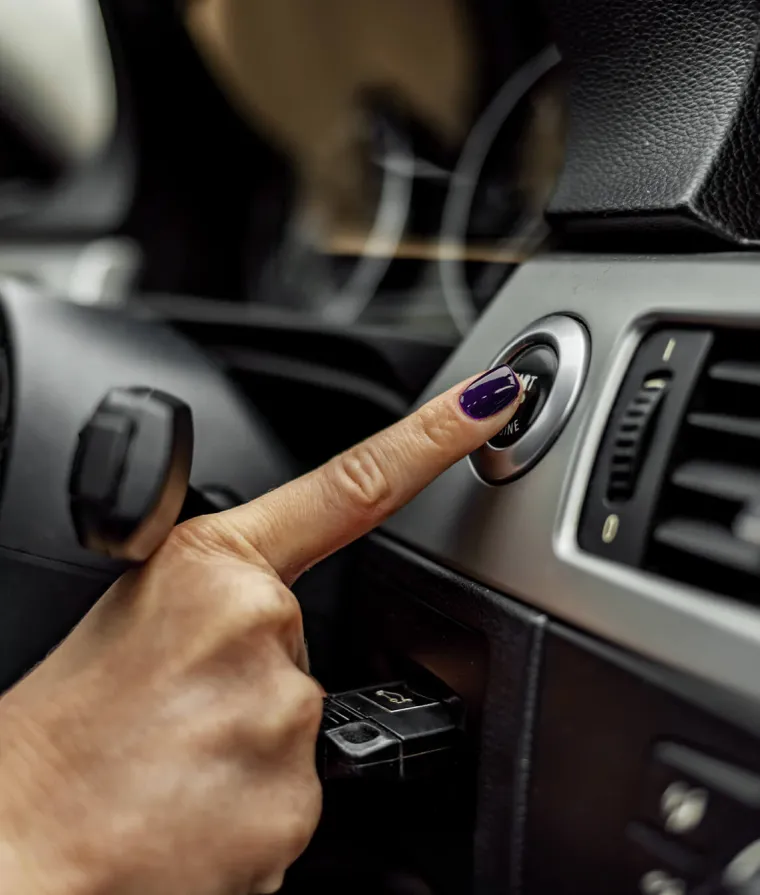 Quelqu'un appuie sur un bouton de démarrage d'une voiture