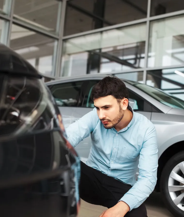 Un homme inspecte une voiture
