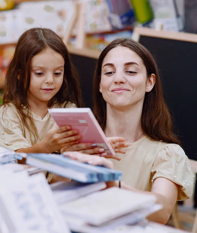 Une mère et sa fille regardent des livres