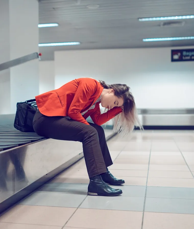 Quelqu'un est assis sur le bord d'un carrousel de bagages