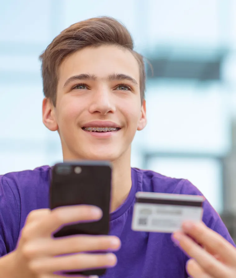 Un jeune homme tient une carte de crédit dans ses mains