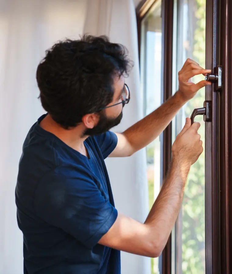 Un homme verrouille ses fenêtres