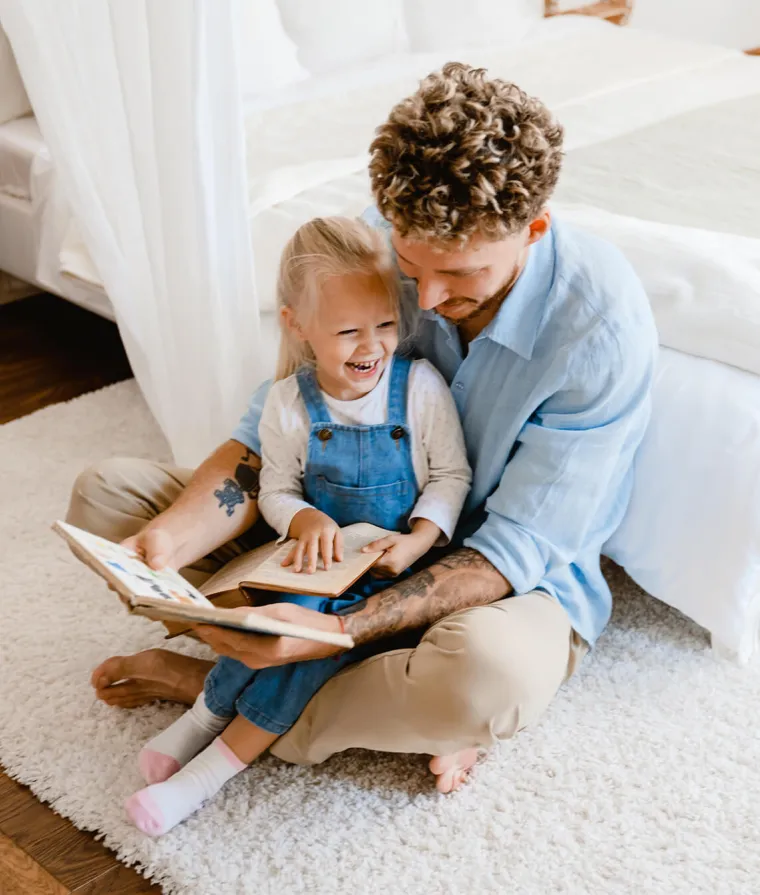 Un père lit un livre avec sa fille