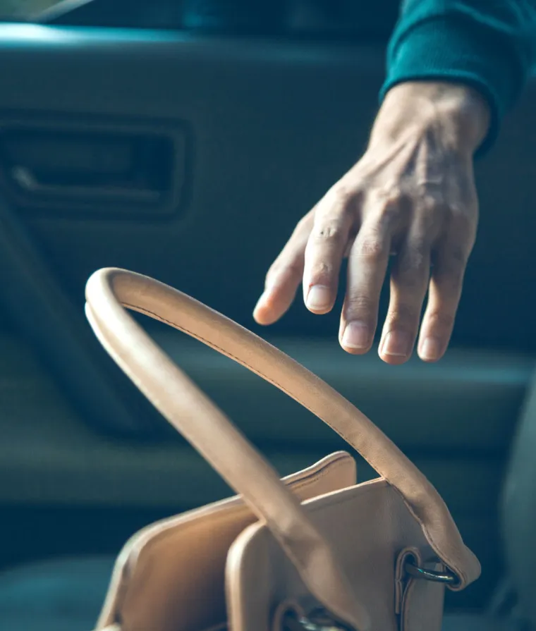 Quelqu'un s'apprête à voler un sac à main dans une voiture