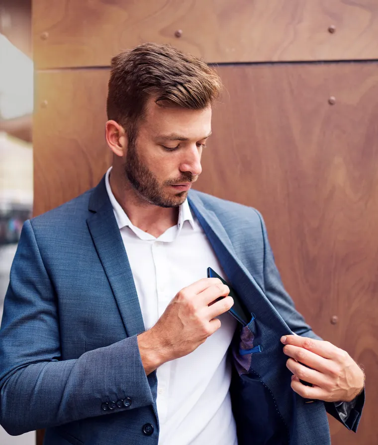 Un homme ranger son cellulaire dans sa veste