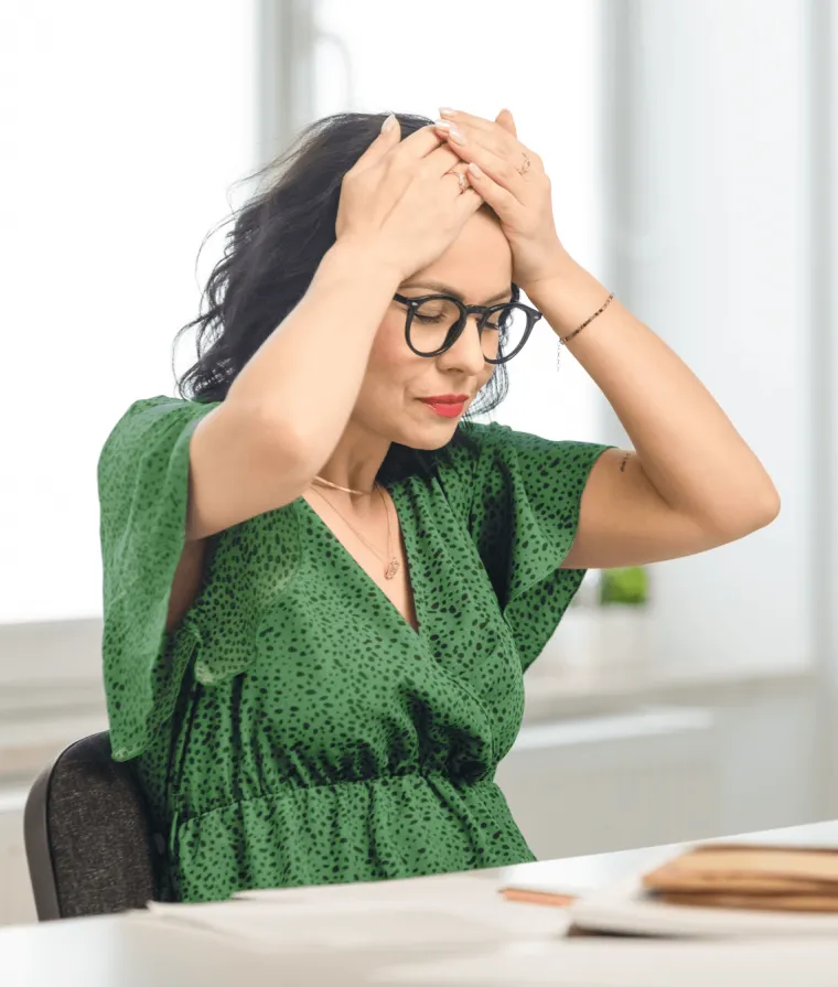 Une femme se tient la tête avec les mains