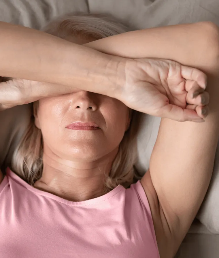 Une femme se couvre le visage de ses mains