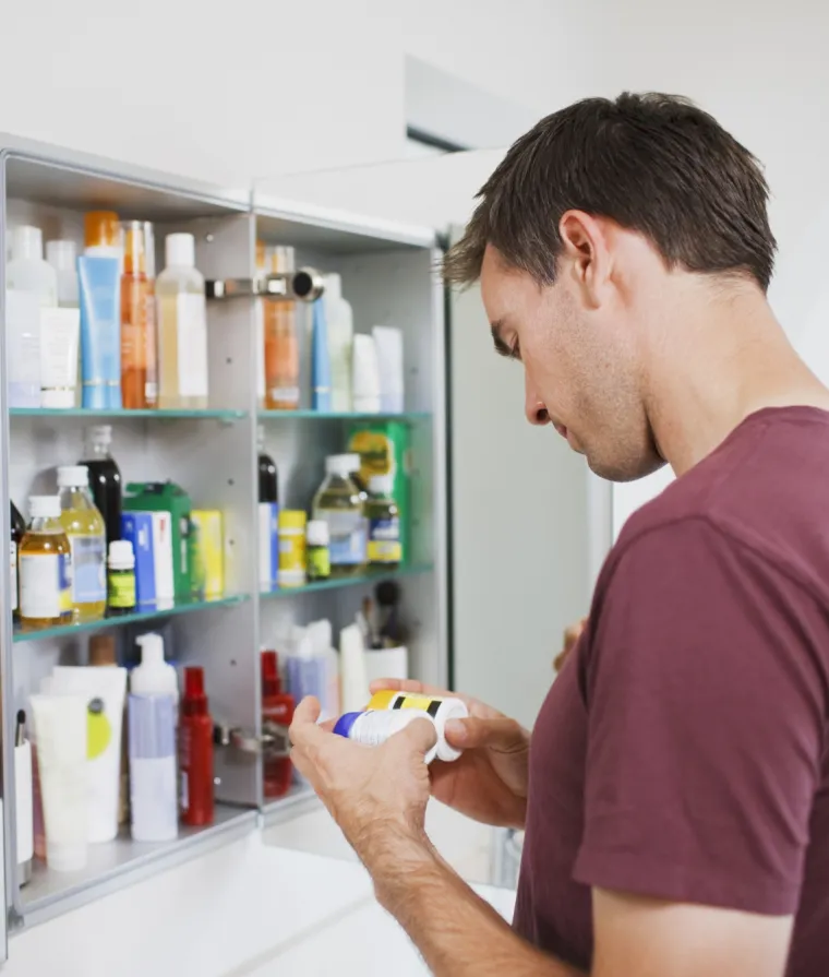 Un homme regarde plusieurs médicaments