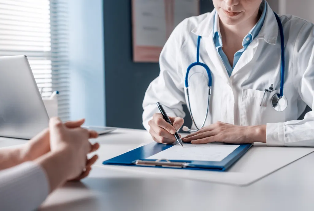 Un médecin écrit sur une tablette de papier